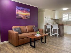 a living room with a couch and a table at Quarterdeck Apartments in Gladstone