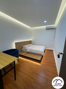 a bedroom with a bed and a desk and a table at Home2828Stay - ROOMS ONLY in Sibu +5 photos