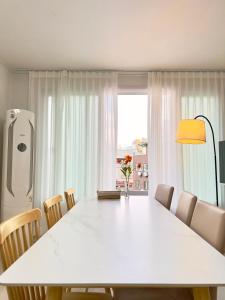 a white dining room table with chairs and a large window at Open Special #Guro Station 5 minutes on foot #Hongdae and Gangnam Subway Direct #Gocheok Dome #7-person family and group accommodation in Seoul