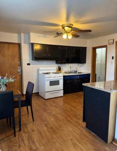 a kitchen with black cabinets and a ceiling fan at Location! Location! 2bd 1bth spacious apartment! in Chicago +15 photos