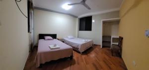 a room with two beds and a ceiling fan at Hospedaje Luciana in Pucallpa