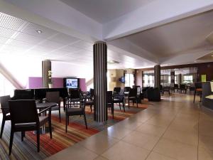 a dining room with tables and chairs and a grand piano at Mercure Hexagone Luxeuil in Luxeuil-les-Bains