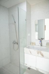 a bathroom with a shower and a tub and a sink at Thảo Aparment Hạ Long in Ha Long