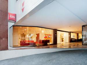 a store front with a large window with red furniture at ibis Santos Gonzaga Praia in Santos