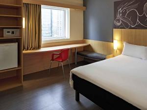 a hotel room with a bed and a desk and a chair at ibis Rio de Janeiro Centro in Rio de Janeiro