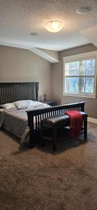 een slaapkamer met een bed met een bank en een raam bij Rocky View Bed & Breakfast in Calgary