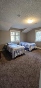 twee bedden in een slaapkamer met twee ramen bij Rocky View Bed & Breakfast in Calgary