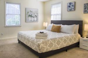 1 dormitorio con 1 cama con 2 lámparas y 2 ventanas en Game Room - 100 inch projector - By Marsh, en Savannah