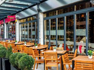 a restaurant with wooden tables and chairs in front of a building at ibis Bristol Centre in Bristol