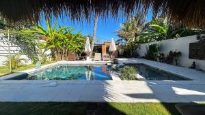 een zwembad in de tuin van een huis bij Villa Benih Cinta in Lovina +23 foto's