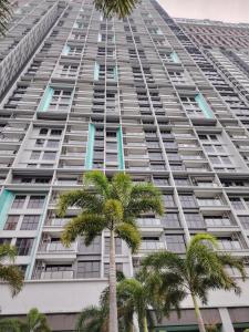 a tall building with palm trees in front of it at Trion Residence Kuala Lumpur by Centrix in Kuala Lumpur