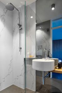 a bathroom with a sink and a glass shower at Breathtaking Sydney Harbour Views from Stylish Harbourside Studio in Sydney +7 photos