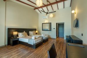 une chambre avec un lit, un bureau et une télévision dans l'établissement Lavendish Beach Resort, à Unawatuna