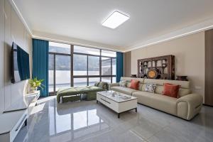 een woonkamer met een bank en een tafel bij 花筑庐江满山红遍民宿 