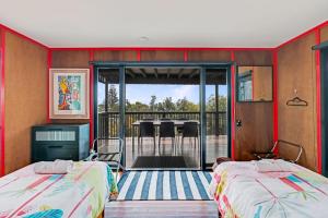a bedroom with two beds and a balcony at 2/38 Booran Street in Point Lookout
