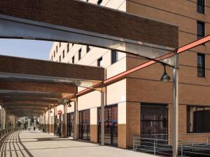 a brick building with a walkway next to a street at Ibis Malaga Centro Ciudad in Málaga