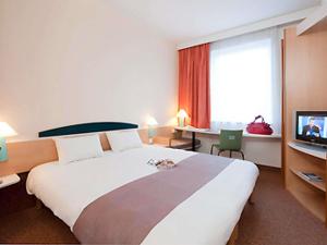 a hotel room with a large bed and a tv at ibis Luxembourg Sud in Livange +40 photos