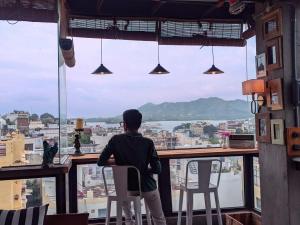 a man sitting on a chair looking out of a window at Bunkyard in Udaipur