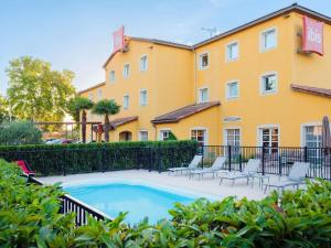 a swimming pool in front of a building at ibis Manosque Cadarache in Manosque