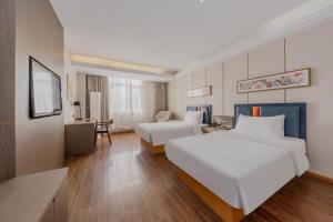 a large hotel room with two beds and a television at Yitel Shanghai Hongqiao Railway Station National Convention and Exhibition Center in Fangjiayao +266 photos