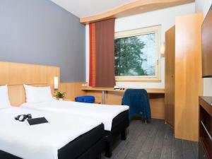 a hotel room with two beds and a window at Ibis Como in Grandate +69 photos