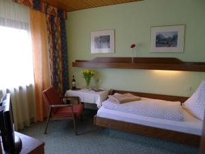 1 Schlafzimmer mit 2 Betten, einem Tisch und einem Stuhl in der Unterkunft Landhaus Schoenen in Sasbachwalden