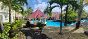 a resort with a swimming pool and palm trees at La Fourchette villa in Palmar