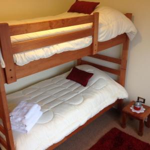 a bedroom with two bunk beds with white sheets at Apartment Villarrica Holidays in Villarrica