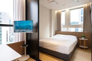 a bedroom with a bed and a flat screen tv at MSstay Myeongdong in Seoul