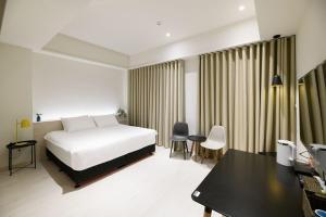 安平区にある樸寓國際青年旅舍のベッドと机があるホテルの部屋