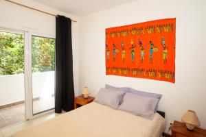 Un dormitorio con una cama y un cuadro en la pared. en Jardin d'Ivandry, en Antananarivo