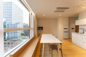 a kitchen with a white table and a large window at MSstay Myeongdong in Seoul