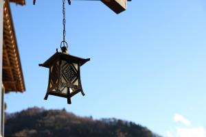 a lantern hanging from a building with a mountain in the background at Hotel Asafuji in Fujikawaguchiko