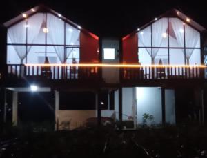 a house with a deck at night with lights at Cabin Wetan Kali Dieng in Diyeng