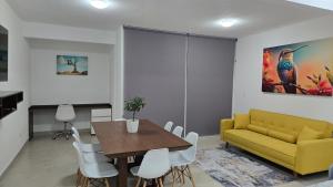 a living room with a yellow couch and a table at Paraíso Liverte Cancún 603 in Cancún