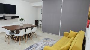 a living room with a yellow couch and a table at Paraíso Liverte Cancún 603 in Cancún