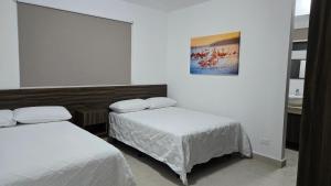 a room with two beds and a picture on the wall at Paraíso Liverte Cancún 603 in Cancún