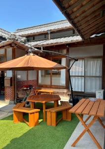 a picnic table and bench with an umbrella at いろどり荘 in Imabari +27 photos