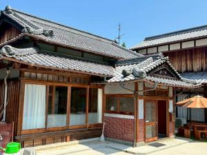an asian style building with a tiled roof at いろどり荘 in Imabari
