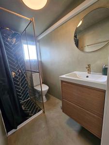 a bathroom with a shower and a sink and a mirror at Holiday Home With A Fantastic View in Allinge