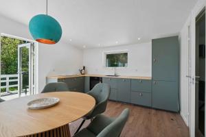 a kitchen with a wooden table and chairs at Holiday Home With A Fantastic View in Allinge +14 photos