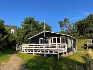 a black house with a white fence in front of it at Holiday Home With A Fantastic View in Allinge