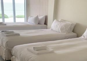 three white beds in a room with a window at Dromana Relaxation Escape by Ready Set Stay in Dromana +30 photos