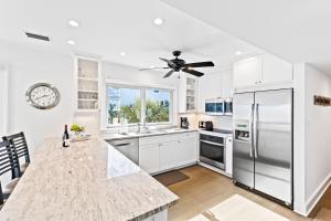 una cucina con armadi bianchi e frigorifero in acciaio inossidabile di New Listing! Linkside Court 21 - Tennis/Pickleball a Isle of Palms
