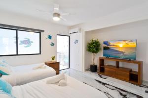 a bedroom with two beds and a flat screen tv at Luxury home-heated Pool-2bedroom in Cancún +24 photos