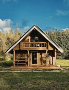 a log cabin with a porch and a deck at 2-bedroom, fenced yard, sauna, 10 min to Pärnu in Pärnu