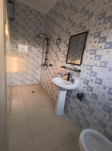 une salle de bain avec un lavabo et des toilettes dans l'établissement Kigali Mechatronics Place, à Kigali