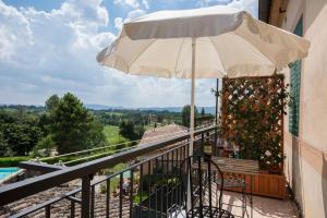 a balcony with an umbrella and a bench and a pool at Villa Sant’Andrea in Siena +57 photos