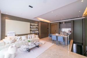 Una sala de estar con un sofá blanco y una cocina. en ZHome-SuHe Luxury Mansion-Near NanJing Road, en Shanghái