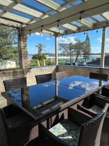 a table and chairs on a patio with a glass table top at Ingenia Holidays Nambucca Heads in Nambucca Heads